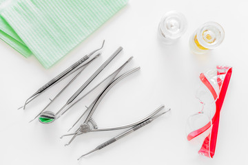 Dentists accessories. Tools, safety glasses and pills on white background top view
