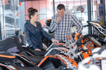 Fototapeta na wymiar portrait of positive couple choosing a new motorbike