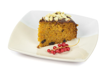 Carrot cake with almond flakes and red currant on a plate