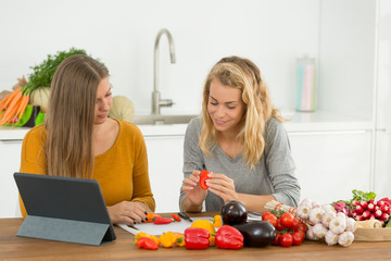woman and teanager folowong recipe on pad