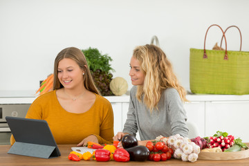 woman and teanager folowong recipe on pad