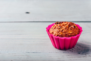 Oatmeal muffin in pink bakeware.