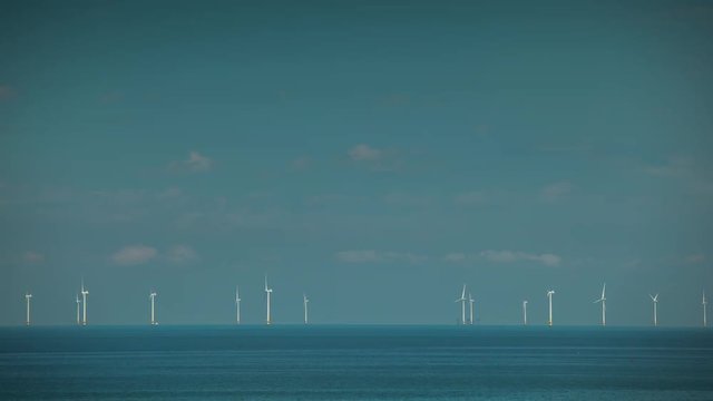 timelapse of offshore wind turbines producing clean renewable energy in the north sea, kent, uk