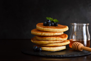 Homemade oat pancakes with honey and blueberries for breakfast on a stone plate. Good morning!