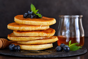 Homemade oat pancakes with honey and blueberries for breakfast on a stone plate. Good morning!
