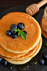 Homemade oat pancakes with honey and blueberries for breakfast on a stone plate. Good morning!