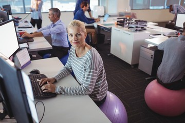 Portrait of businesswoman working at desk while sitting on