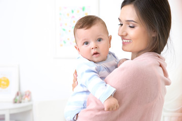Mother holding cute baby after bathing at home