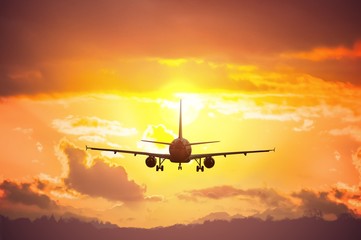 Fototapeta na wymiar Silhouette of airplane flying in sunset.