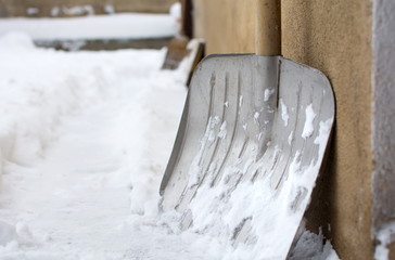 Fototapeta premium Snow shovel in snowed front yard