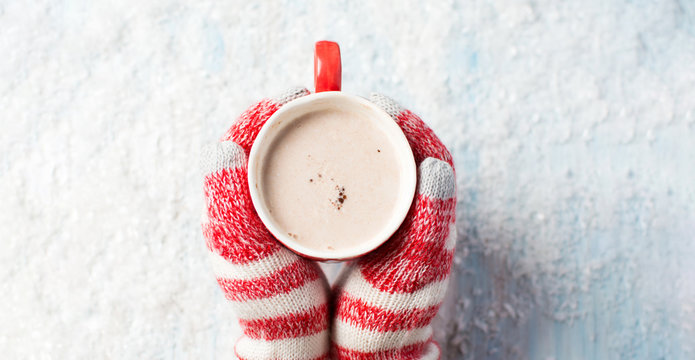 female hands in gloves holding hot chocolate