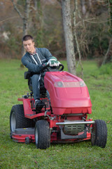 Young man driving mower