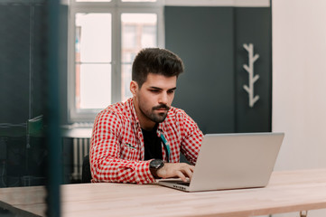 Handsome businessman working with laptop in office.