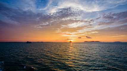 Obraz premium Beautiful natural landscape of colorful cloud sky and sun at sunset over the sea in Surat Thani province, Thailand, 16:9 widescreen