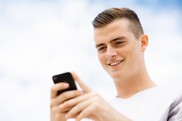 Male runner with his mobile smart phone standing outdoors
