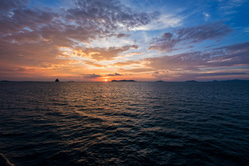 Beautiful natural landscape of colorful cloud sky and sun at sunset over the sea in Surat Thani province, Thailand