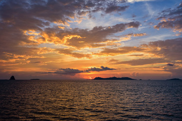 Obraz na płótnie Canvas Beautiful natural landscape of colorful cloud sky and sun at sunset over the sea in Surat Thani province, Thailand