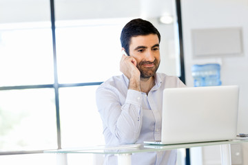 Confident young man in smart casual wear holding phone