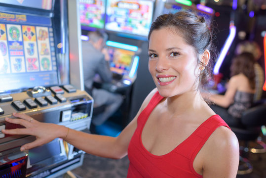 beautiful woman in red dress playing slot machine
