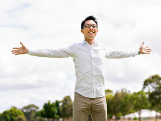 Young happy and successful businessman during his break in park