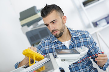 male electrician checking device with digital multimeter