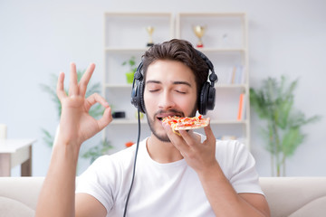 Man eating pizza having a takeaway at home relaxing resting
