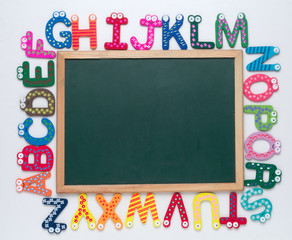 Blank chalkboard with alphabets surrounding