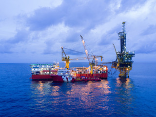 Fototapeta premium Aerial View of Tender Drilling Oil Rig (Barge Oil Rig) in The Middle of The Ocean at Sunrise Time