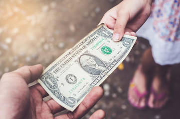 Father gives 1 one dollar money to children Concept of family lifestyle, Spend money economically