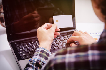 male hands holding credit card typing numbers on computer keyboard :online shopping concept
