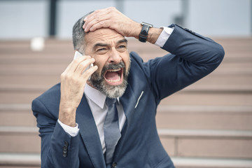 Senior business man yelling at an employee, shocked with the bad news he's receiving