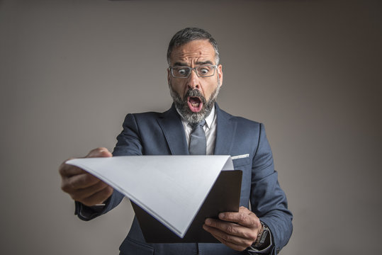 Senior Business Man Shocked With Financial Report, Company Is In Bad Shape, He's Gasping With Worry