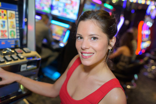 happy woman next to a slot machine