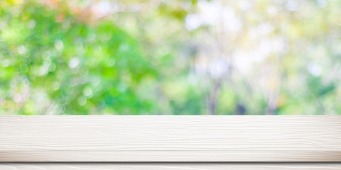 Empty white wood table over blurred tree with bokeh background, for product display montage