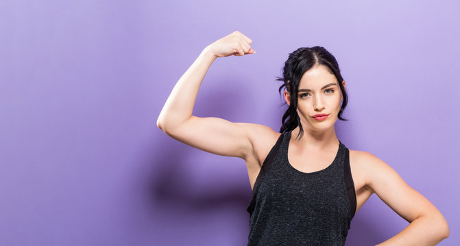 Powerful young fit woman on a solid background