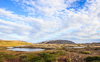 Beautiful summer icelandic landscape panoramic view with grassland, colorful mountain ranges, and beautiful sky as a background. Iceland, Europe