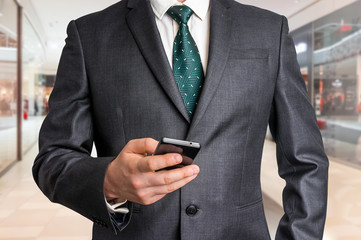 Businessman in black suit with mobile phone