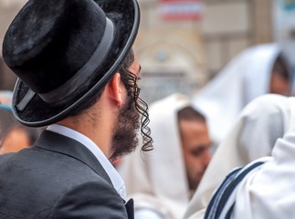 An adult Hasid in a traditional hat and with long payos. Prayer of Hasidim.