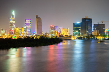 Fototapeta na wymiar Night view of Business and Administrative Center of Ho Chi Minh city on Saigon riverbank in twilight, Vietnam. 