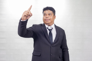 Fat businessman in a suit show pointing finger