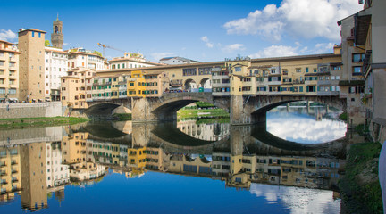 The Ponte Vecchio bridge reflected in the River Arno in Florence 