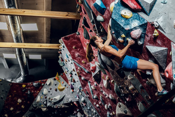 Professional female climber on a bouldering wall.