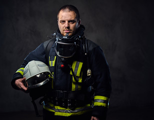 Obraz premium Firefighter dressed in uniform holds safety helmet.
