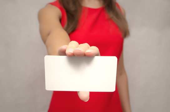 Young Woman In Red Dress Showing A Visiting Card In Her Hand. Contact Us.