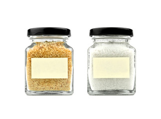 Brown sugar and salt set in a glass bottle isolated on white background. Black lid. Modern and stylish. Close up.