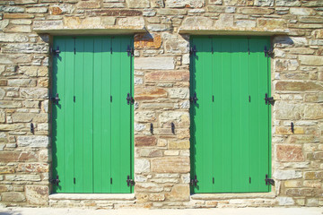 Greece, double green doors on stone wall