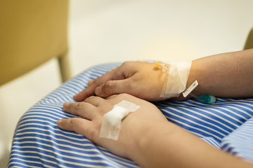 Woman hand with IV saline intravenous on hand in hospital white background.