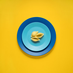 Dinner is served / Dinner is served / Creative concept photo of kitchenware, painted plate with food on it on yellow background.
