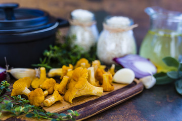 Ingredients for preparing risotto, Italian food. Fresh chanterelle mushrooms with arborio and herbs. 