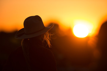 cowgirl with hat in the sunset - obrazy, fototapety, plakaty